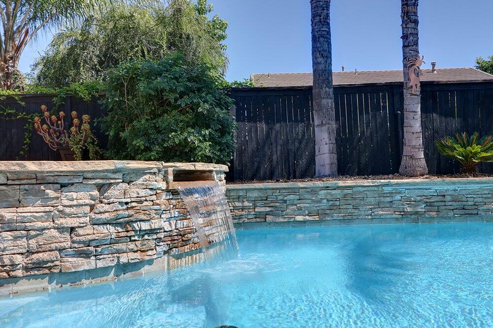 Backyard oasis featuring a crystal clear swimming pool and outdoor patio area in Riverside, California.